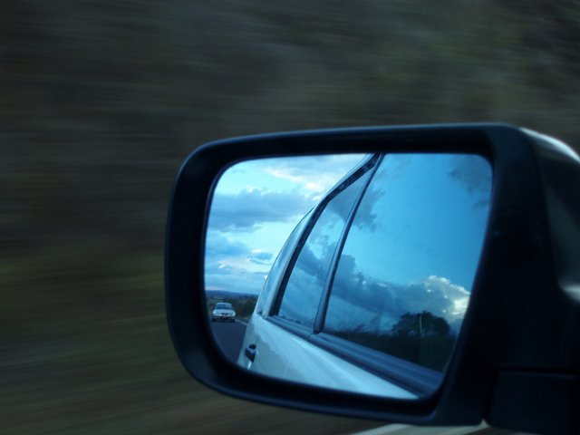 car mirror with someone following