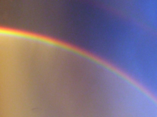 arc of a rainbow reaching into a dark stormy sky