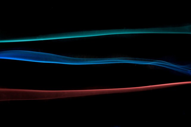 organically curving line of smoke in red green and blue primary colours