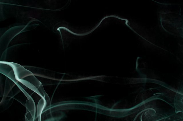 a background of green mystical layers of smoke on black