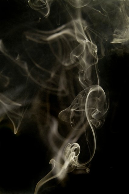 a black background with flash lit smoke wisps