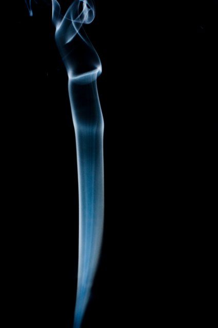 an organically curving line of smoke against a black background