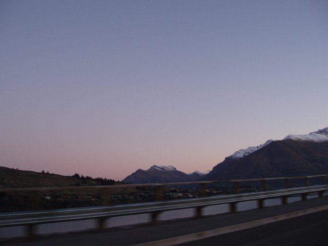 low key image of the remarkables at dusk through a crash barrier