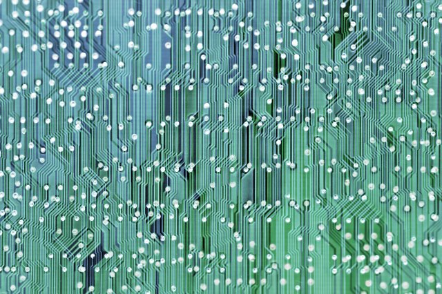 Full frame background of green and blue complex circuit tracks on a printed electronic circuit board