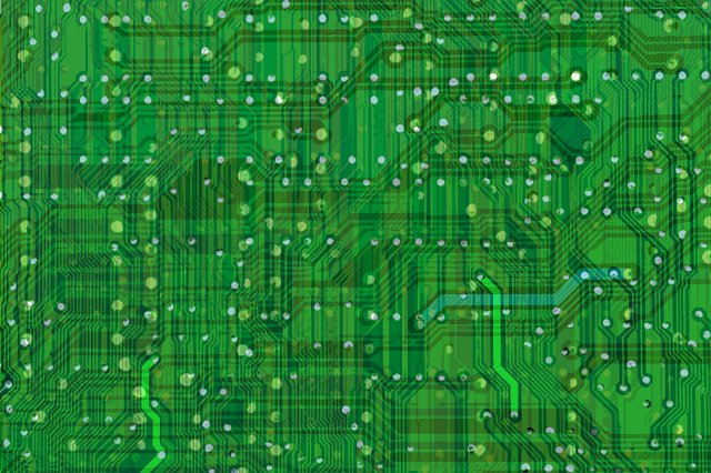 A close up of green wiring and circuits on a motherboard.
