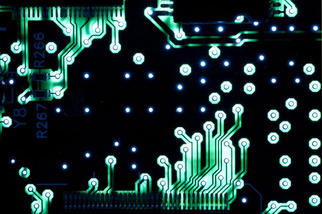 Green conductive electronic tracks on a printed circuit in a close up full frame view