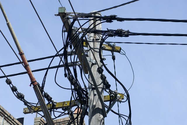 a tangle of cables on an urban power pole