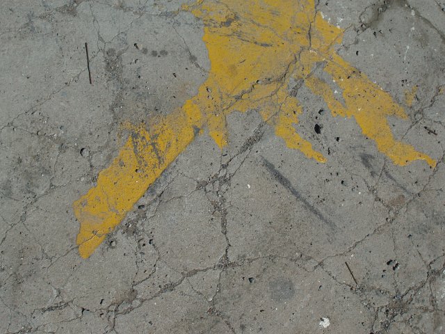 a splat of yellow paint on dry cracked earth