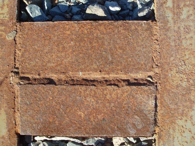 a heavy iron girder pitted with surface rust