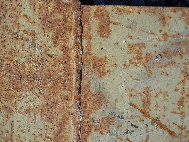 a heavy iron girder pitted with surface rust