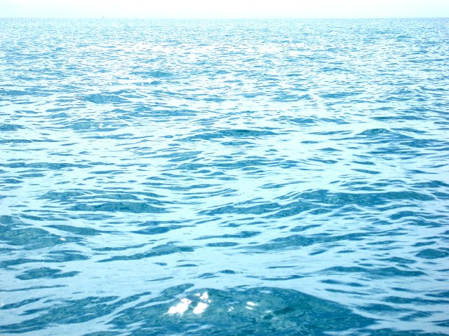 bright blue cyan coloured water surface with distant horizon