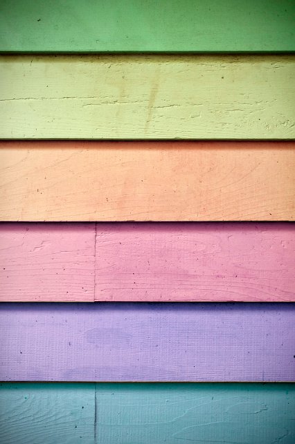 Background texture of overlapping wooden slats in the colours of the rainbow