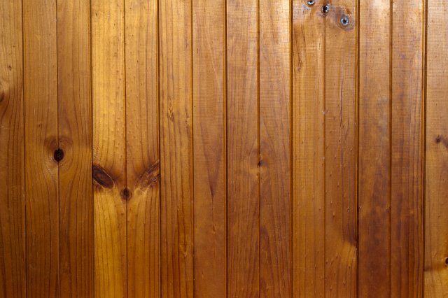 background of vertical tongue and groove wood cladding boards lit from above