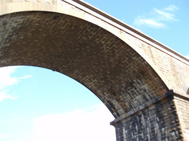 overexposed image of a railway viaduct stone arch