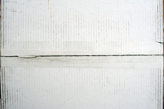 White cardboard background showing the bottom of a carton with the center join sealed with tape, full frame view
