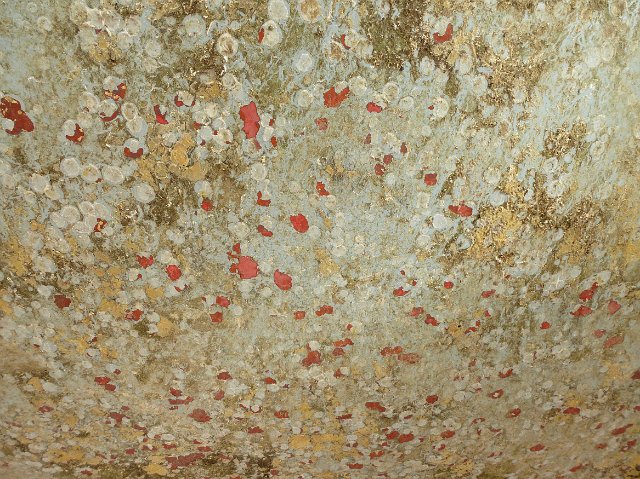 Old grungy dirty surface background texture with red blotches on a rough surface with stains and discoloration