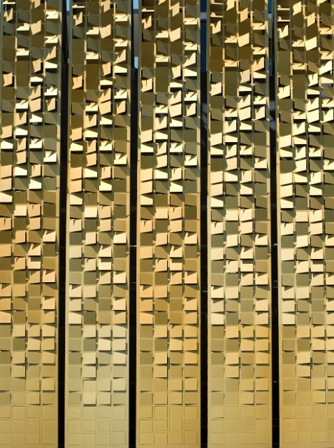 gold colored architectural metal screen clading cut in square shapes
