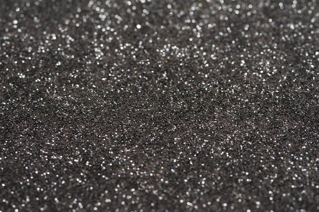 Selective focus on a black glitter textured surface