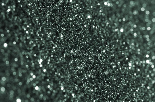 Selective focus background of small black glitter pieces