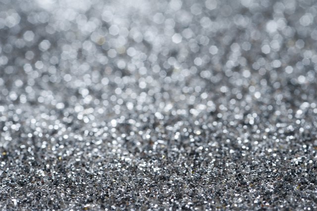 Abstract Background of Sparkling Silver Steel Gray Glitter Spread Across Full Frame in Selective Diffuse Focus