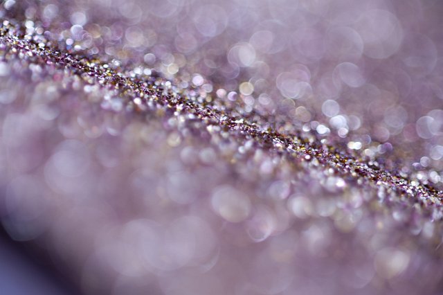 A glittering purple coloured background with selective focus