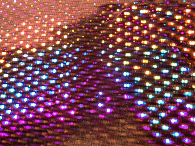 angled image of a sheet of holographic material with lots of colorful points of light