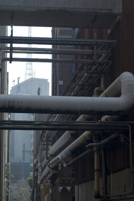 a maze of pipes in a disused brewery building