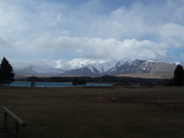 cyan glacial lake with mountain range backdrop