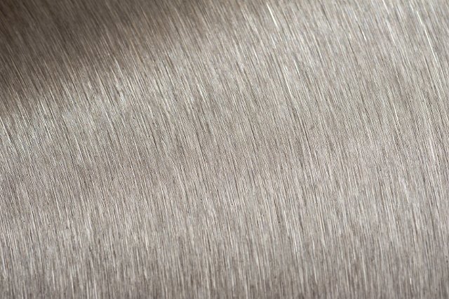 Background texture of brushed steel in closeup detail showing the striations in the metal
