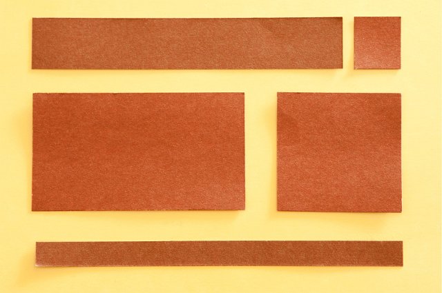 squares of brown paper on yellow frame spaces for blocks of text in a design