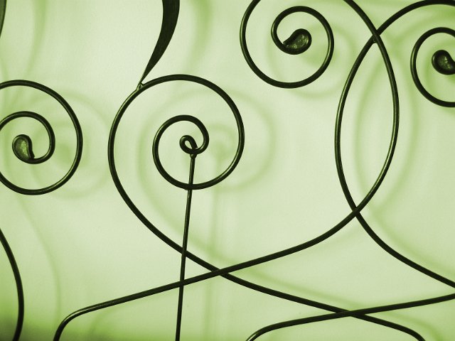 arabesque metal shapes on a green background with shadows