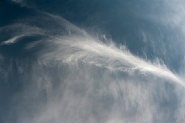 a wispy trail of vapour in a blue sky