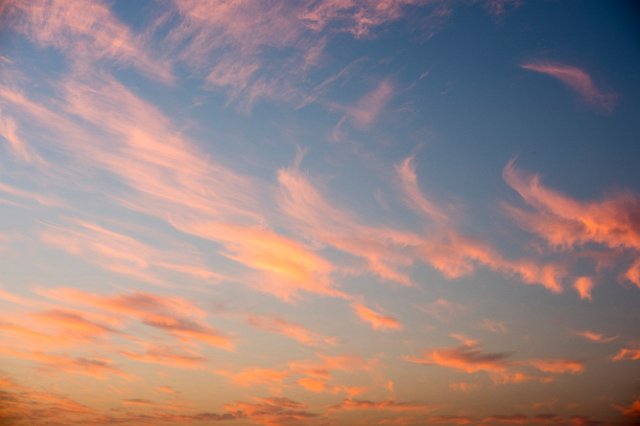 pink orange glowing cirrus clouds forming a beautiful sunset sky