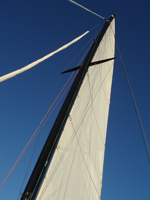 a boat sail pictured against a clear blue sky