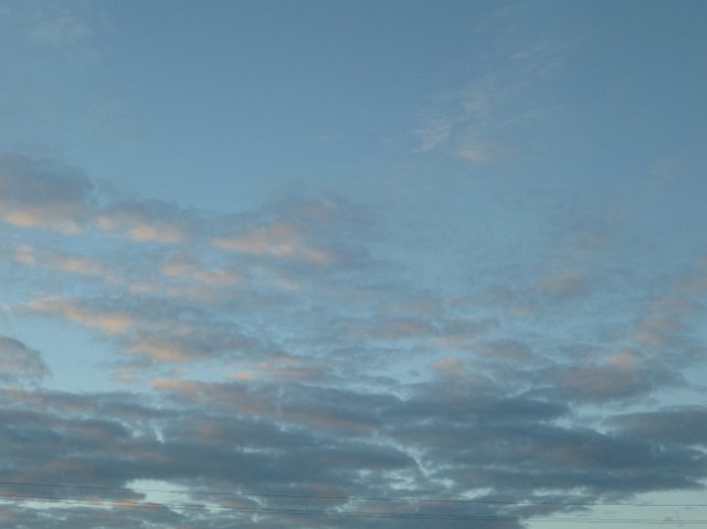 an evening sky with a layer of clearing cloud