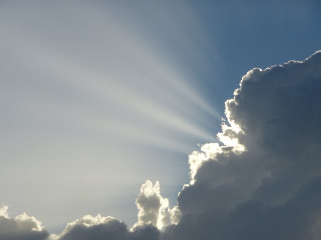 bright shafts of light emerging from a foreboding storm cloud