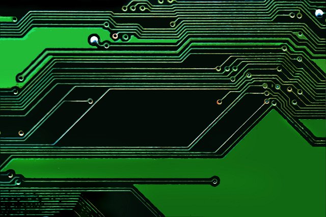 Close up view of a diagonal electronic circuit on a colorful green background in a technology concept