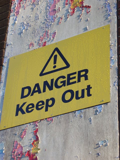 weathed paint and a danger keep out sign